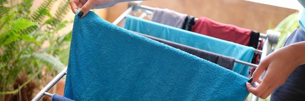 Casalinga vestiti appesi sull'asciugatrice a casa concetto di lavanderia di routine per i lavori domestici del primo piano