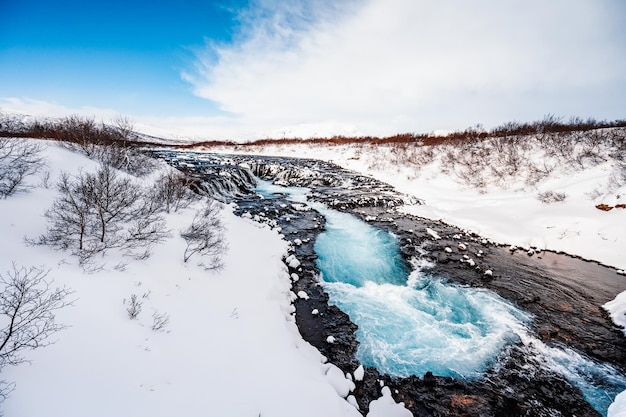 Cascata Bruarfoss La "cascata più blu d'Islanda" L'acqua blu scorre sulle pietre Inverno Islanda Visita l'Islanda