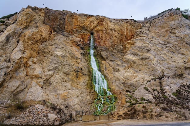 Cascata d'acqua che esce da un tunnel scavato nella montagna della Rocca di Gibilterra