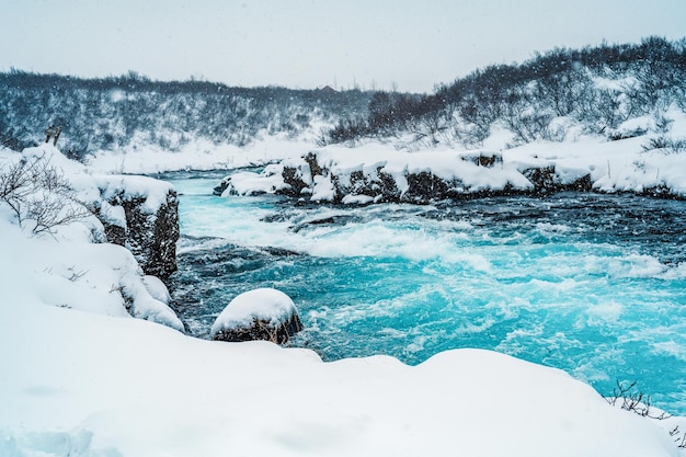 Cascata di Midfoss La "cascata più blu d'Islanda" L'acqua blu scorre sulle pietre Inverno Islanda Visita l'Islanda Escursioni alla cascata di bruarfoss