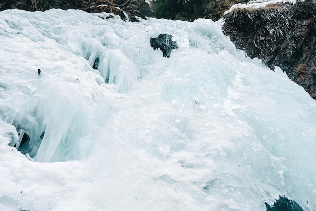 Cascata invernale con acqua ghiacciata e neve