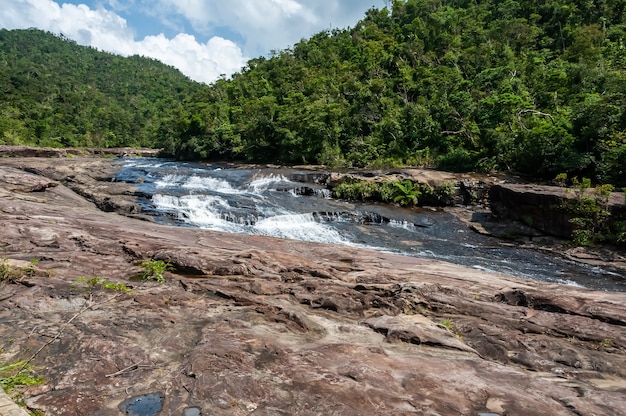 Cascata Kanpire che scorre su una piattaforma di pietra nella giungla