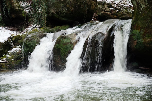 Cascata Scheissentempel, fiume Black Ernz con ponte di pietra coperto di neve, sentiero Mullerthal