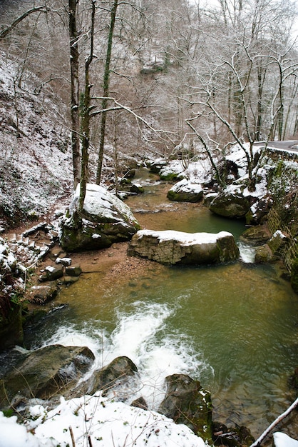 Cascata Scheissentempel, fiume Black Ernz con ponte di pietra coperto di neve, sentiero Mullerthal