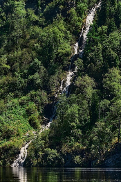 Cascata sulla riva di un lago di montagna. Cade. Russia, Repubblica dell'Altai, Lago Teletskoye, cascata Ayu-Kechpes.