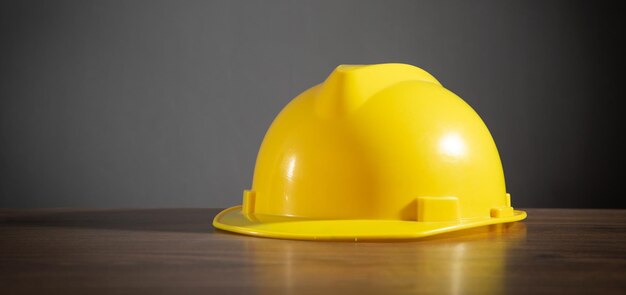 Casco da costruzione giallo sul tavolo di legno