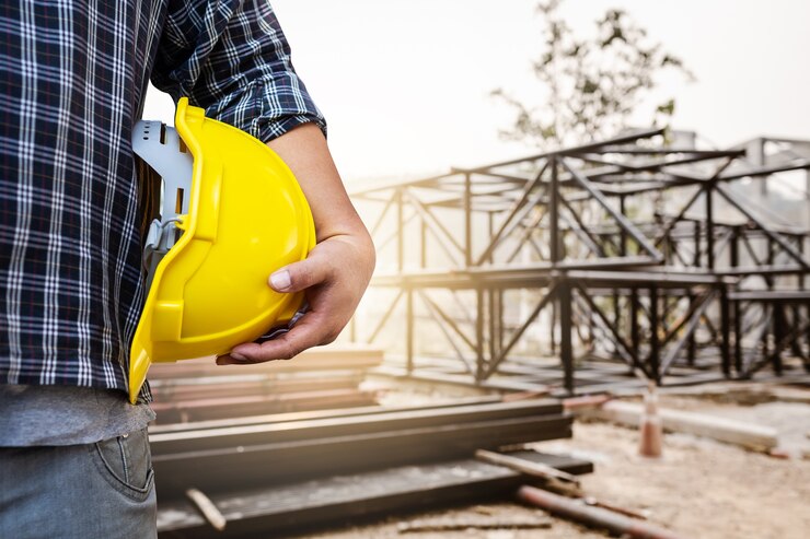 Casco della holding dell&#39;uomo dell&#39;ingegnere con priorità bassa d&#39;acciaio