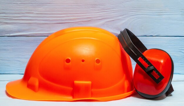 Casco e cuffie arancio della costruzione contro