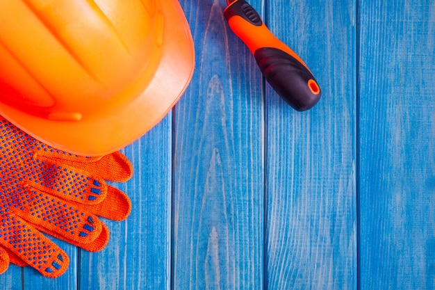 Casco e strumento arancio sui bordi blu d'annata di legno