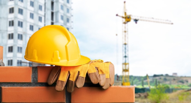 Casco giallo con attrezzatura su sfondo di costruzione