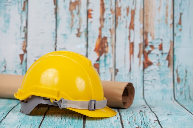 Casco giallo della costruzione su legno e sulla vecchia parete.