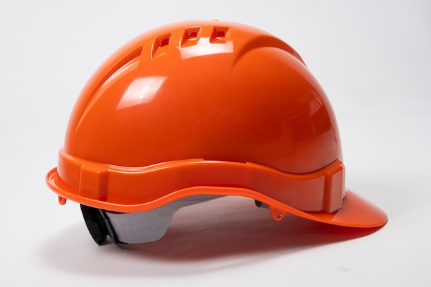 Casco protettivo arancione per ingegnere costruttore su sfondo bianco