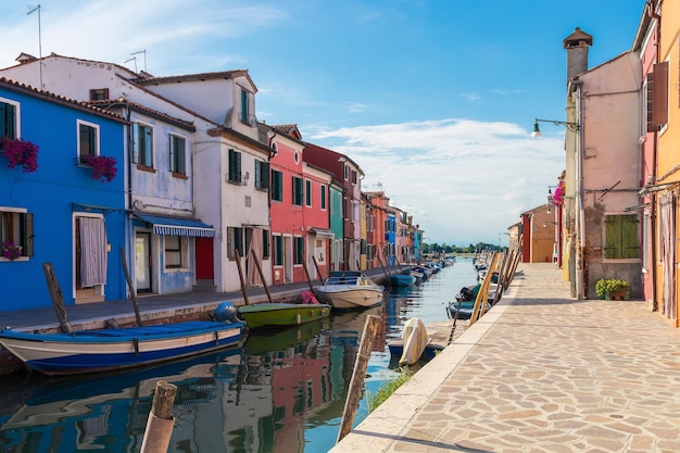 Case colorate multicolori a Venezia sull'isola di Burano Canale stretto con barche a motore lungo le case Giorno soleggiato estivo Focus selettivo