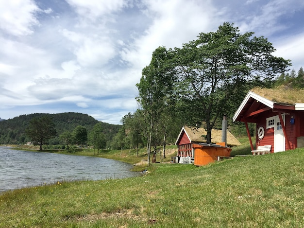 Case di legno rosse con un tetto in erba in stile scandinavo sul lago