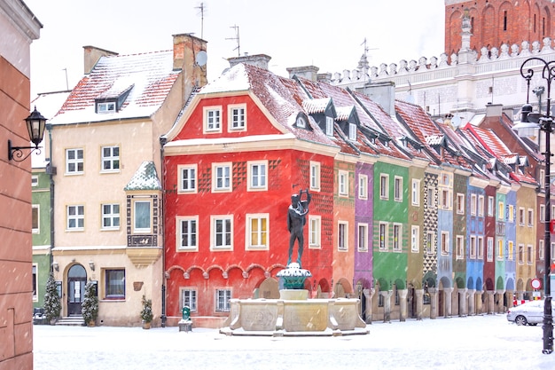 Case di mercanti e fontana in Piazza del Mercato Vecchio nella Città Vecchia nella giornata invernale innevata, Poznan, Poland