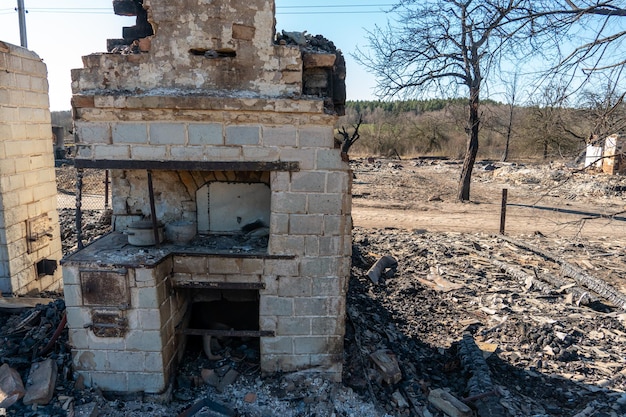 Case distrutte a seguito di un incendio in Russia Mattoni e parti di muri vari oggetti per la casa finestre rotte ricoperte di cenere giacciono sulla superficie della terra Disastro naturale