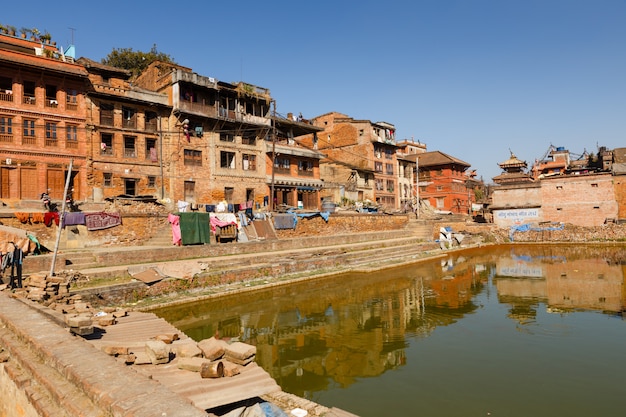 Case narlane nepalesi tradizionali vicino allo stagno verde in Bhaktapur, Nepal