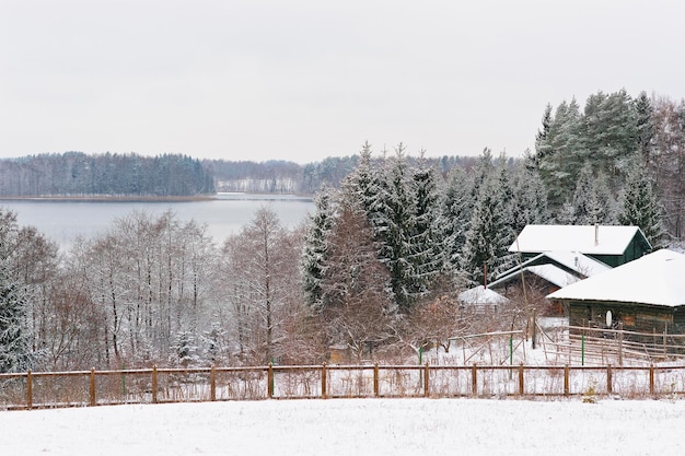 Case sotto la neve vicino a un lago nell'orario invernale