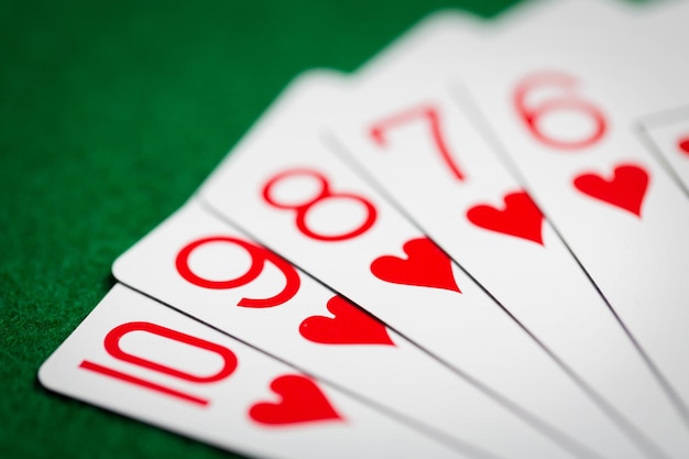 casinò, gioco d'azzardo, giochi d'azzardo, concetto di rischio e intrattenimento - mano di poker a colore diretto di carte da gioco su panno verde