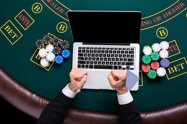 Casinò, gioco d'azzardo online, tecnologia e concetto di persone - primo piano del giocatore di poker con carte da gioco