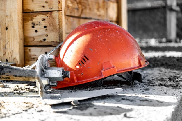 Cassaforma per fondamenta in cemento armato con casco da costruzione arancione Costruzione della fondazione di un nuovo casco da costruzione per la casa Protezione dei lavoratori Ingegneria della sicurezza