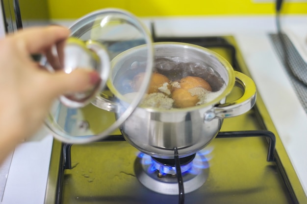 Casseruola con uova bollenti su una stufa a gas