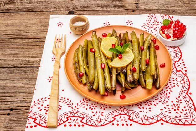 Casseruola di fagioli verdi al forno condita con semi di sesamo, melograno, menta e limone