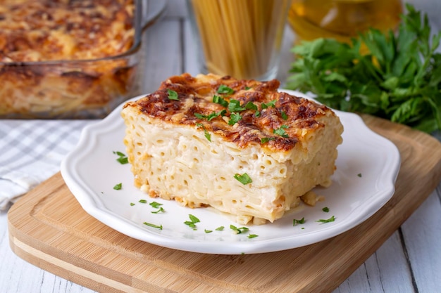 Casseruola di pasta besciamella condita con mozzarella fusa e servita in una teglia bianca su un tavolo Nome turco firinda makarna o firin makarna