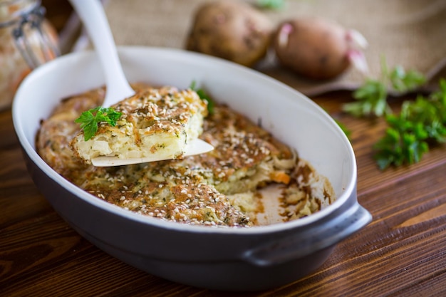 Casseruola di patate con cavolo e spezie in una forma di ceramica