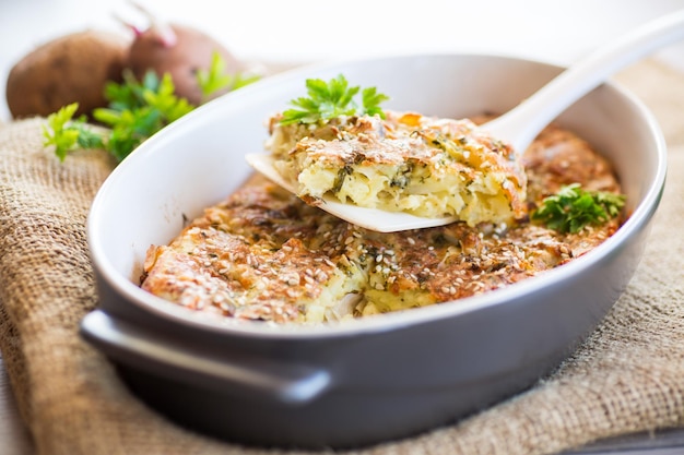 Casseruola di patate con cavolo e spezie in una forma di ceramica