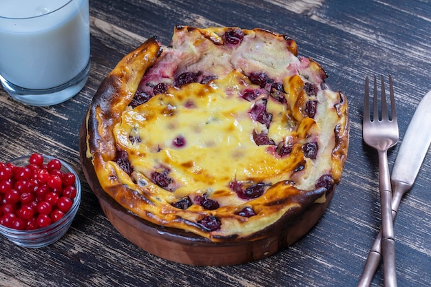 Casseruola di ricotta dolce con uva spina e semola su tavola di legno Ciotola in ceramica con casseruola di ricotta al forno