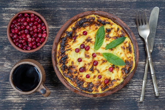 Casseruola di ricotta dolce con uvetta e semolino sulla tavola di legno