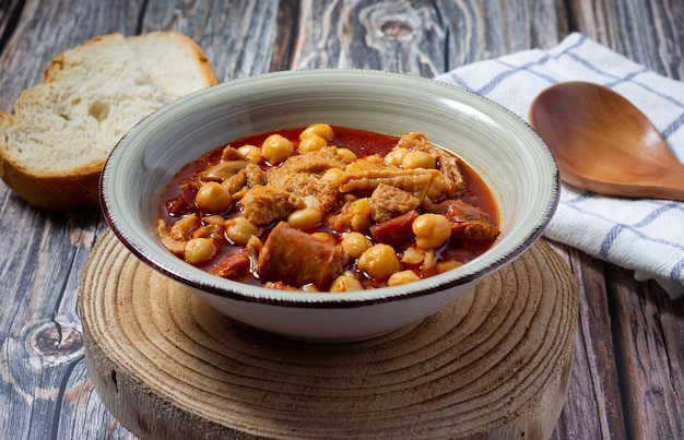 Casseruola di trippa sul fondo e cucchiaio di legno Comfort food invernale Callos a la madrilena