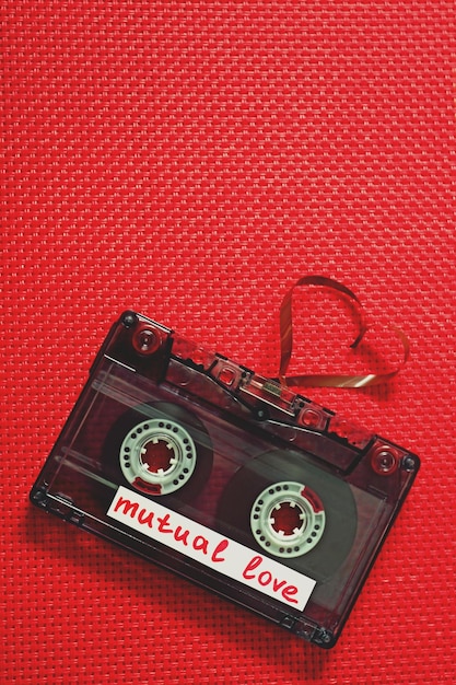 Cassetta audio retrò con nastro a forma di cuore su sfondo di tessuto rosso
