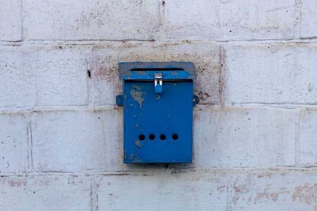 Cassetta postale blu in stile retrò sul muro di mattoni Vecchia cassetta postale di ferro