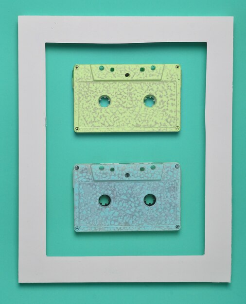 Cassette audio degli anni '80 in una cornice bianca su un verde colorato