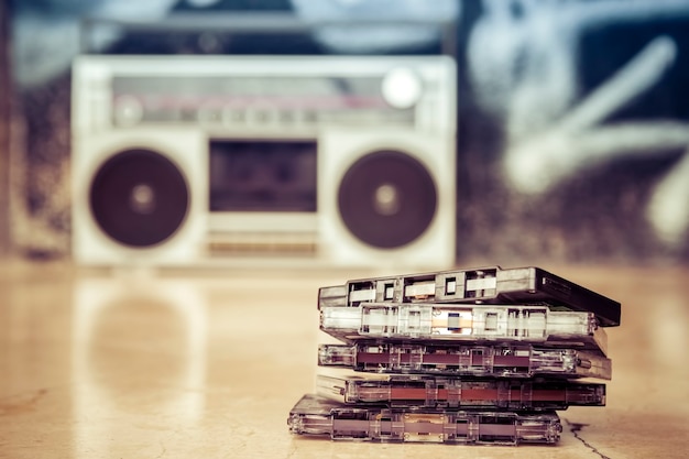 Cassette audio impilate e appoggiate a terra con un vecchio stereo portatile