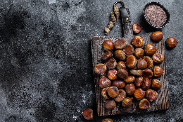 Castagne crude su un tagliere di legno.