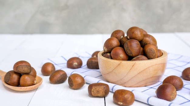 Castagne in una ciotola su un tavolo di legno.