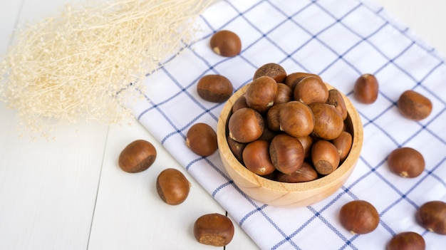 Castagne in una ciotola su un tavolo di legno.