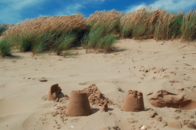 Castelli di sabbia rotti su una spiaggia sabbiosa.