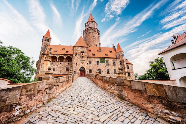 Castello di Bouzov Castello da favola nel paesaggio dell'altopiano ceco Castello con chiesa bianca torri alte tetti rossi muri in pietra Repubblica Ceca