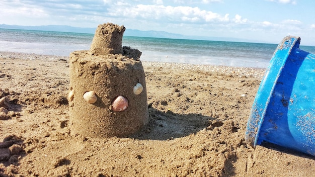 Castello di sabbia sulla spiaggia contro il cielo