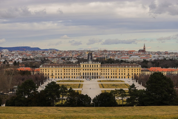 Castello di Schönbrunn molto colorato tra il cielo e l'erba in una giornata nuvolosa.