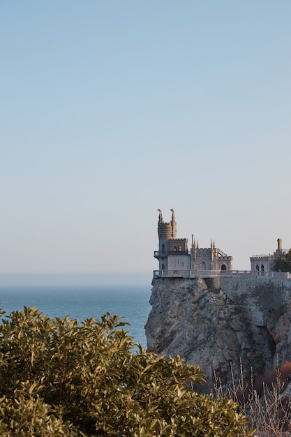 Castello medievale sul bordo di una scogliera, vegetazione tropicale e mare, paesaggio