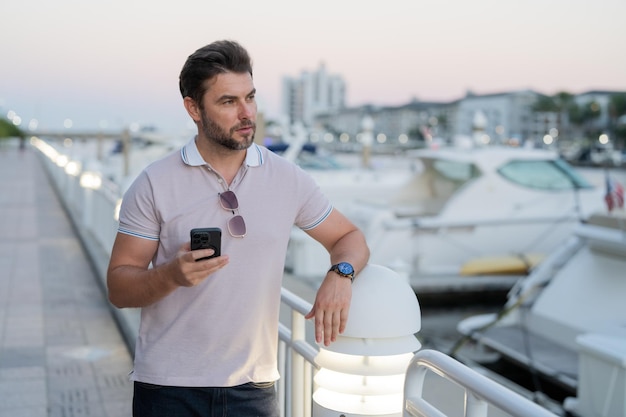 Casual bell'uomo che chiacchiera al telefono in città urbana uomo ben vestito che parla al telefono affari all'aperto