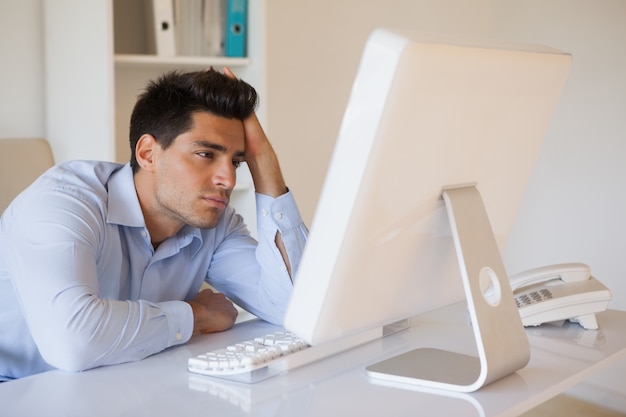 Casual uomo d&#39;affari accasciato alla sua scrivania