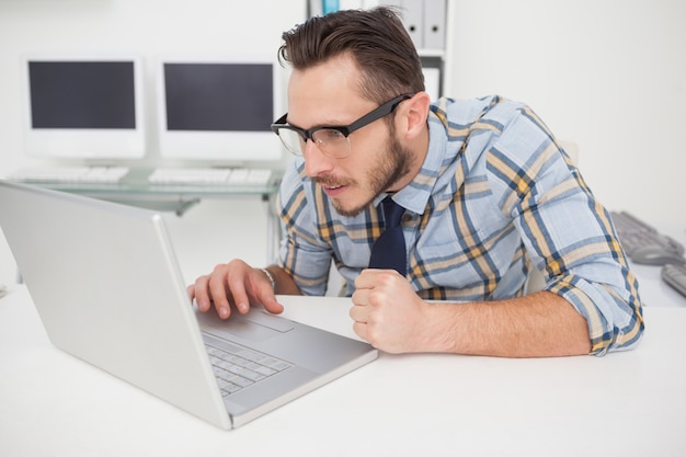 Casual uomo d&#39;affari alla sua scrivania di lavoro sul computer portatile