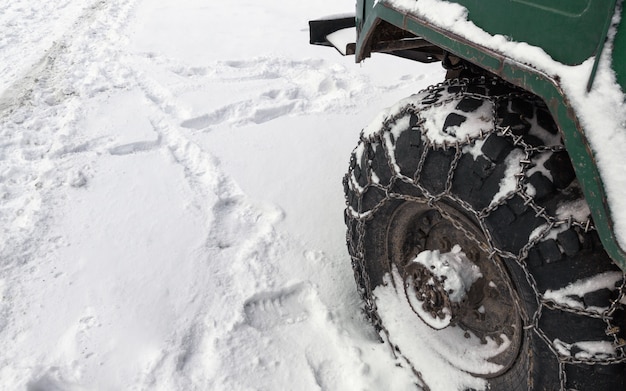 Catena di metallo sulla gomma del camion fuoristrada in strada innevata