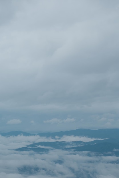 Catena montuosa con sagome visibili attraverso la nebbia blu mattutina